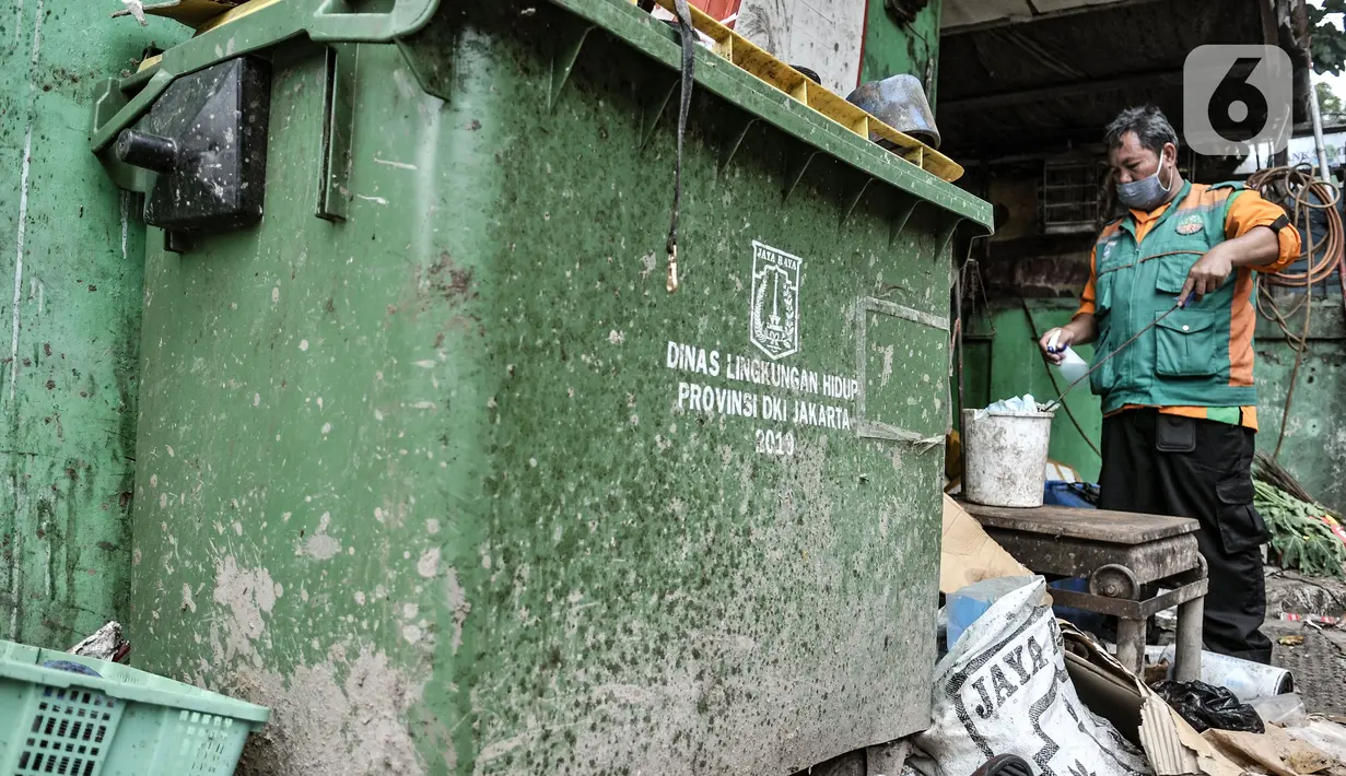Ikhasundin menyemprotkan cairan disinfektan di dekat kotak penyimpan khusus limbah medis di Dipo Sampah Kecamatan Pademangan, Ancol, Jakarta, Rabu (24/2/2021). Ikhasnudin mewakili petugas di Dipo Ancol berharap agar masyarakat lebih bijak dalam menangani sampah masker. (merdeka.com/Iqbal S. Nugroho)