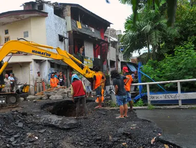 Petugas Dinas PU melakukan perbaikan Jembatan Inspeksi Kali Grogol yang ambles di Komplek Hankam, Slipi, Jakarta, Senin (21/3). Penyebab Amblesnya jembatan diduga terjadi pergeseran tanah dibagian pondasi jembatan. (Liputan6.com/Faisal R Syam)