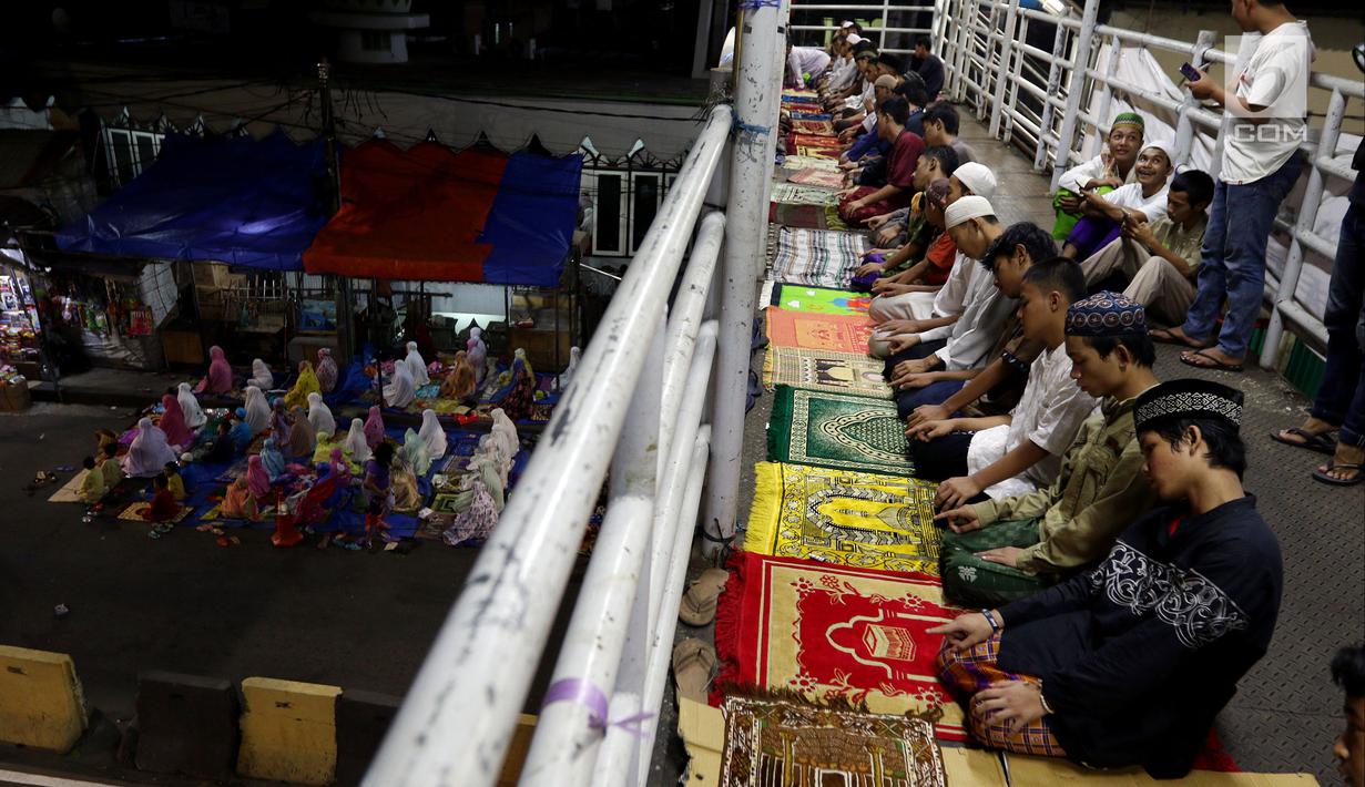 Sejumlah warga melaksanakan salat tarawih di atas JPO Musala Miftahul Jannah di Kawasan Pasar Gembrong, Jakarta, Kamis (17/5). Puluhan warga Pasar Gembrong antusias melaksanakan salat tarawih pada awal bulan suci Ramadan. (Liputan6.com/JohanTallo)