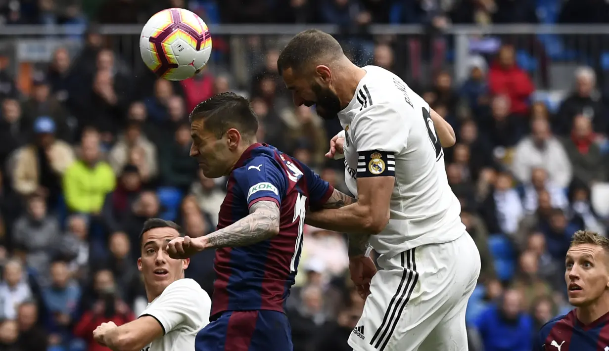 Striker Real Madrid, Karim Benzema, mencetak gol ke gawang Eibar pada laga La Liga di Stadion Santiago Bernabeu, Sabtu (6/4). Real Madrid menang 2-1 atas Eibar. (AFP/Gabriel Bouys)
