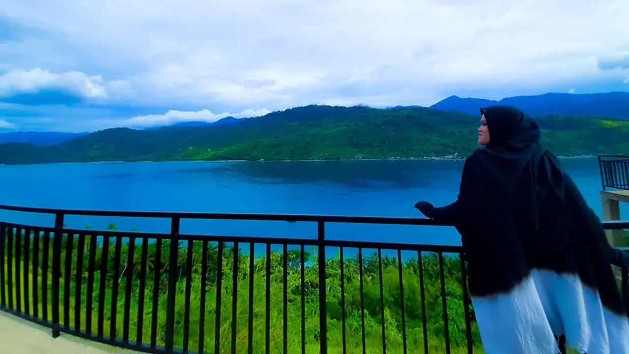 Seorang wisatawan asyik menikmati pemandangan Pulau Diyonumo, Kabupaten Gorontalo Utara. (Liputan6.com/Arfandi Ibrahim)