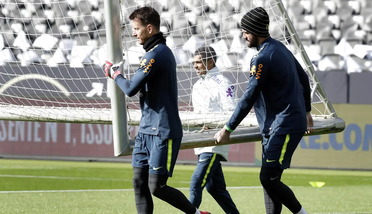 Kiper Brasil, Neto dan Alisson, menggotong gawang saat latihan jelang laga persahabatan di Berlin, Jerman, Selasa, (27/3/2018). Brasil akan berhadapan dengan Jerman. (AP/Michael Sohn)