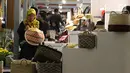 Pengrajin menghias salah satu topi caping yang dipamerkan pada KriyaNusa 2018 di Jakarta Convention Center, Jakarta, Sabtu (29/9). Terdapat 13 stand kriya dan 21 stand kuliner di KriyaNusa 2018. (Liputan6.com/Helmi Fithriansyah)