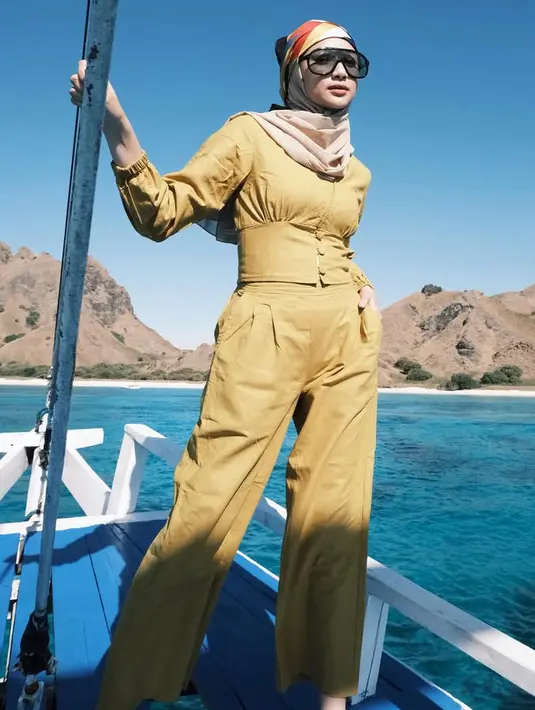 Liburan di pantai bisa mengenakan warna cerah seperti Anselma. Ia mengenakan atasan crop dengan aksen obi dipadukan celana high waist warna kuning kunyit. Dipadukan kerudung coklat serta syal colorfull di atas kerudungnya. Tak lupa kacamata hitam.  [@ansellmaputri]