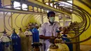 Seorang pekerja medis memantau pasokan tangki oksigen ke berbagai bangsal di sebuah rumah sakit di Lhokseumawe, Aceh, Selasa (7/7/2021). Indonesia memperluas pembatasan untuk memerangi gelombang virus corona COVID-19 yang mematikan. (Azwar Ipank/AFP)