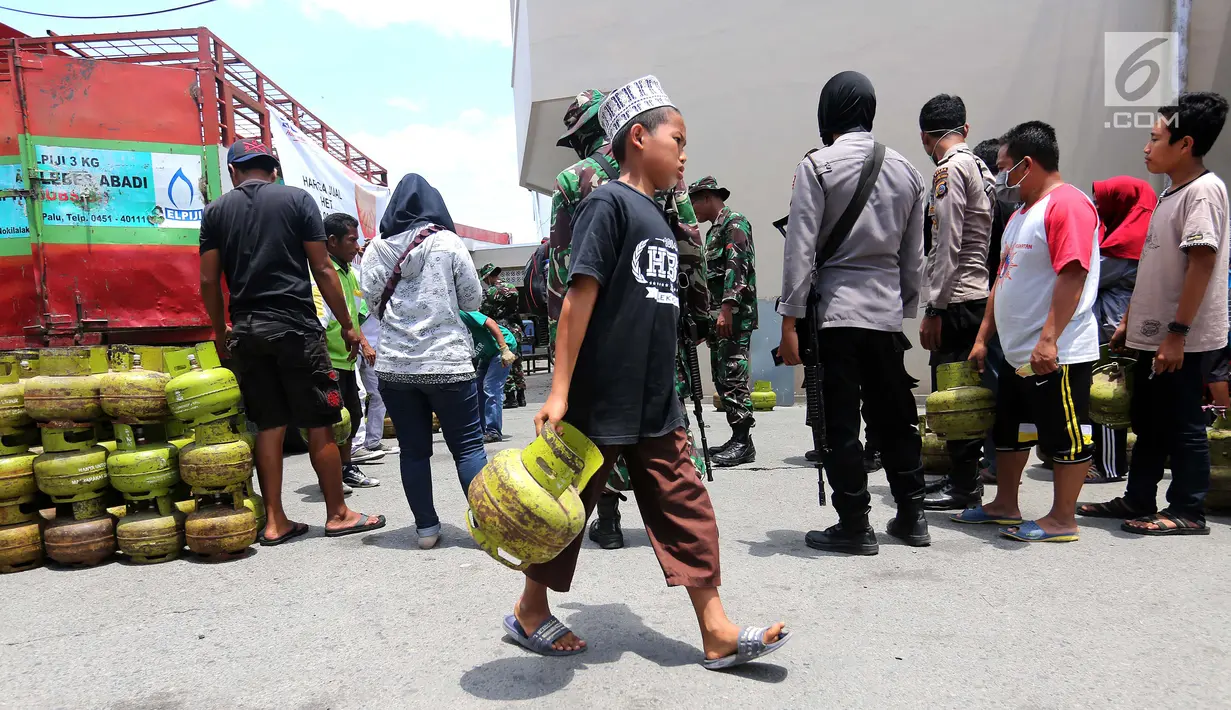 Warga membawa tabung gas elpiji 3 kg saat operasi pasar elpiji di SPBU Ki Hajar Dewantara di Palu, Sulawesi Tengah, Senin (8/10). Pertamina melakukan operasi pasar elpiji 3 kg dan 12 kg yang dijaga aparat polisi dan TNI. (Liputan6.com/Fery Pradolo)