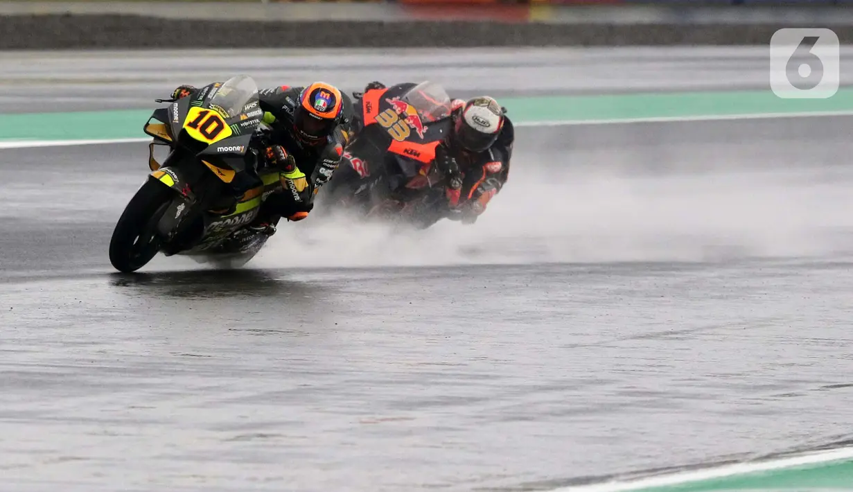 Pembalap MotoGP dari Mooney VR46 Racing Team, Luca Marini (kiri) beradu kecepatan dengan Brad Binder (Red Bull KTM Factory Racing) di lintasan Pertamina Mandalika International Street Sirkuit, Nusa Tenggara Barat, Minggu (20/3/2022). (Liputan6.com/Helmi Fithriansyah)