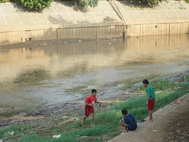 Anak-anak bermain di bantaran Sungai Ciliwung yang mengering, kawasan Kampung Melayu, Jakarta, Jumat (8/11/2019). Curah hujan yang tidak menentu menyebabkan sebagian bantaran Ciliwung masih mengalami kekeringan. (Liputan6.com/Immanuel Antonius)