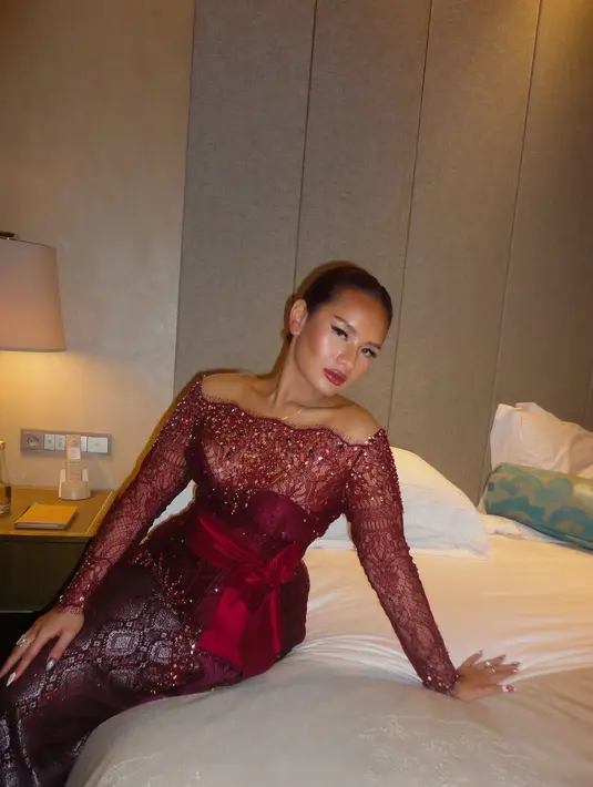 Detail kebaya yang dikenakan Zahwa Massaid di momen resepsi ini memiliki garis leher yang lebar, dengan taburan payet berkilauan di panel bagian depan. Dipermanis dengan aksen selendang merah yang diikatkan di pinggangnya. [@zahwamassaid].