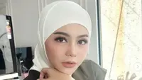 Jenita Janet tampil mengenakan kerudung putih dipadukan vest hijau dengan inner manset putihnya. Credit: Instagram (@jenitajanet)