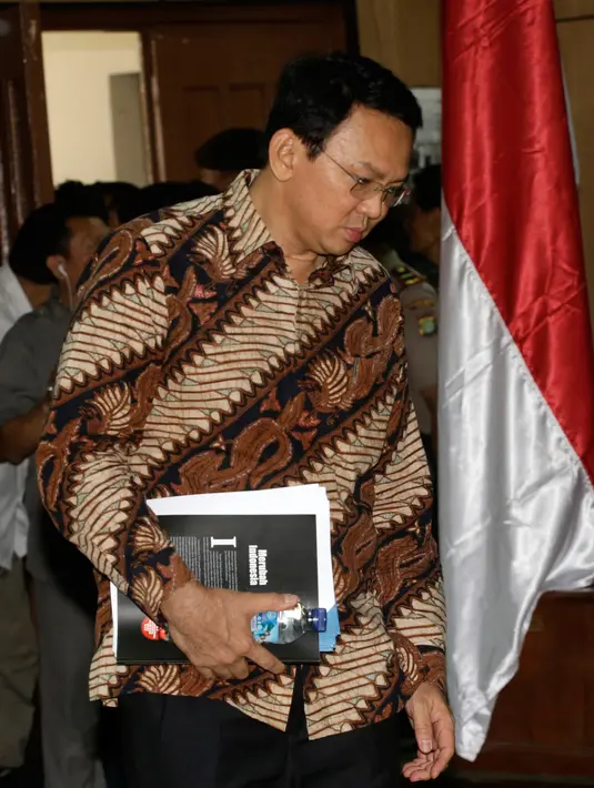 Basuki Tjahaja Purnama atau Ahok berjalan menuju kursi terdakwa untuk menjalani sidang perdana kasus dugaan penistaan agama di PN Jakarta Utara, Selasa (13/12). Sidang hari ini beragenda pembacaan surat dakwaan dari tim JPU. (TATAN SYUFLANA/POOL/AFP)