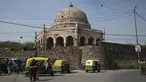 Pengemudi becak menunggu pelanggan di depan Makam Adham Khan abad ke-16, juga dikenal sebagai (Bhool Bhulaiya), di New Delhi (16/2/2022). Makam Adham Khan adalah makam Adham Khan abad ke-16, seorang jenderal Kaisar Mughal Akbar. (AFP/Sajjad Hussain)