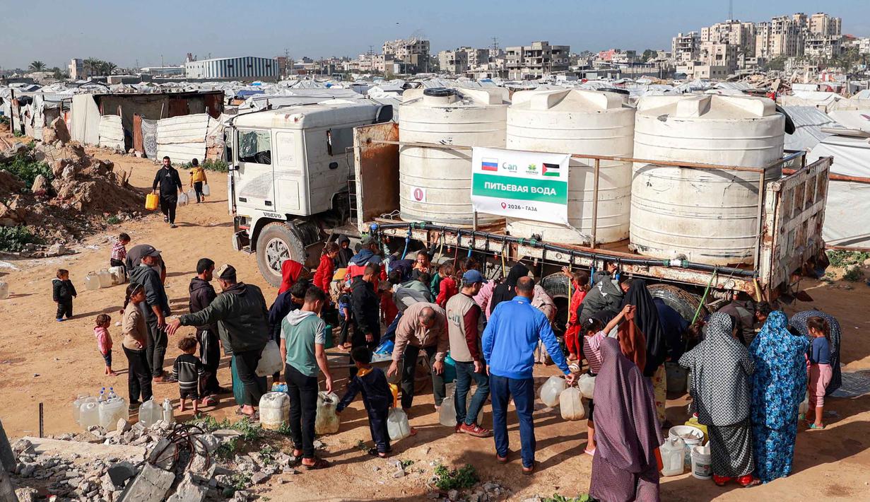 Hal ini diungkap Badan Kemanusiaan Perserikatan Bangsa-Bangsa (PBB) pada Selasa (9/2/2026). Tampak dalam foto, warga mengisi wadah air dari tangki air portabel di kamp pengungsi Palestina Maghazi, Jalur Gaza tengah pada Rabu 11 Februari 2026. (Eyad BABA/AFP)
