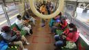 Penumpang KRL Commuterline duduk dalam kereta di Stasiun Bogor, Jawa Barat, Selasa (9/6/2020) pagi. Puluhan polisi, TNI, Satpol PP, dan petugas stasiun diterjunkan untuk memandu penumpang mengantisipasi antrean panjang seperti kemarin. (merdeka.com/Arie Basuki)