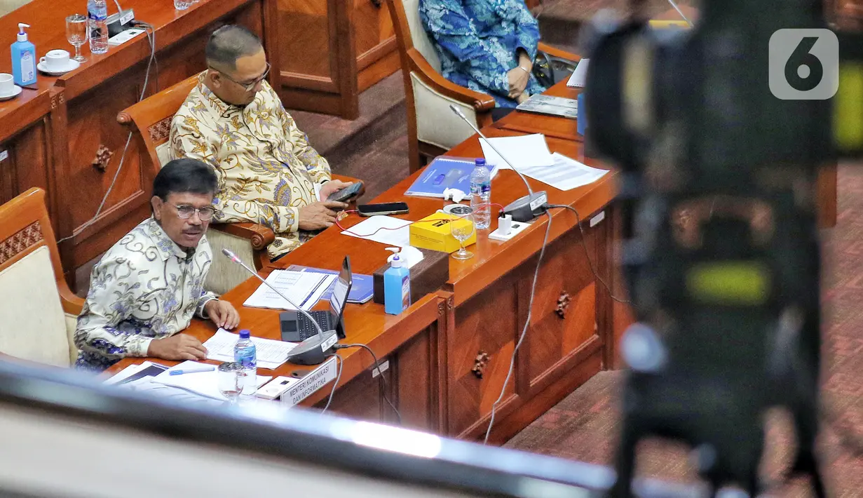 Menkominfo Johnny G. Plate (kiri) saat mengikuti rapat kerja dengan Komisi I DPR terkait evaluasi pelaksanaan Analog Switch Off (ASO) di Kompleks Parlemen Senayan, Jakarta, Rabu (23/11/2022). Dalam rapat tersebut Johnny G. Plate menyampaikan bahwa sebanyak 77 lembaga penyiaran telah bersiaran seluruhnya secara digital dan 503 lembaga penyiaran bersiaran secara analog dan digital. (Liputan6.com/Angga Yuniar)
