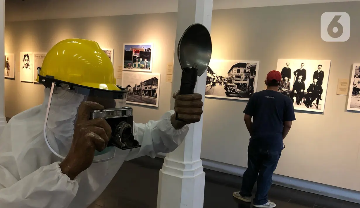 Petugas mengamati karya dalam Pameran Fotografi dan Grafis bertajuk “Indonesia Bergerak: 1900-1942“ di Galeri Foto Jurnalistik Antara, Pasar Baru, Jakarta, Selasa (8/9/2020). Pameran tersebut memperlihatkan rekam jejak intelektual semasa pergerakan nasional. (Liputan6.com/Immanuel Antonius)