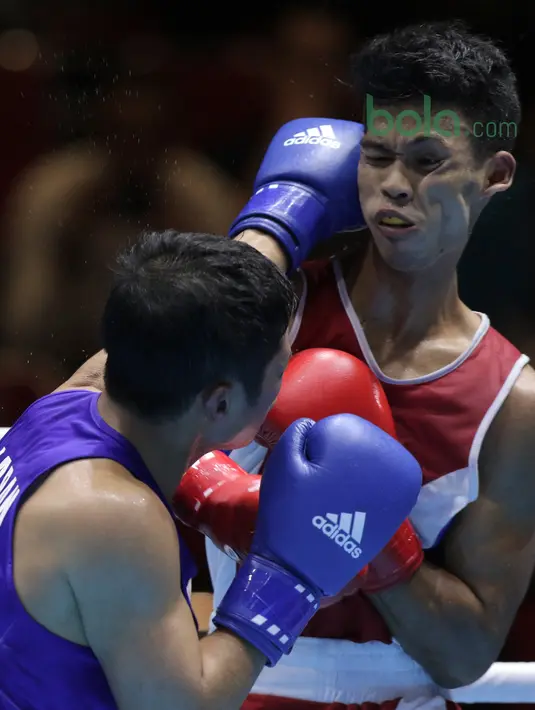 Petinju Indonesia, Grece Simangunsong (kanan) mendapat pukulan petinju Jepang, Hiroaki Kinjo pada semifinal Test Event Asian Games 2018 kelas Welter di Kemayoran, Jakarta (14/2/2018). Simangunsong menang dengan skor 3-2. (Bola.com/Nick Hanoatubun)