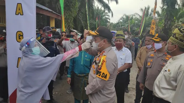 Pemeriksaan suhu badan Kapolda Riau Irjen Agung Setya Imam Effendi di pintu masuk Jaga Kampung Desa Sengkemang, Kabupaten Siak.