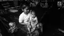 Seorang ibu Suku Baduy Luar sedang memangku anaknya di dalam rumah di lokasi bekas kebakaran Kampung Cisaban II, Desa Kanekes, Banten, Kamis (01/6). Kebakaran pada pekan lalu yang menghanguskan 83 rumah Suku Baduy Luar. (Liputan6.com/Fery Pradolo)
