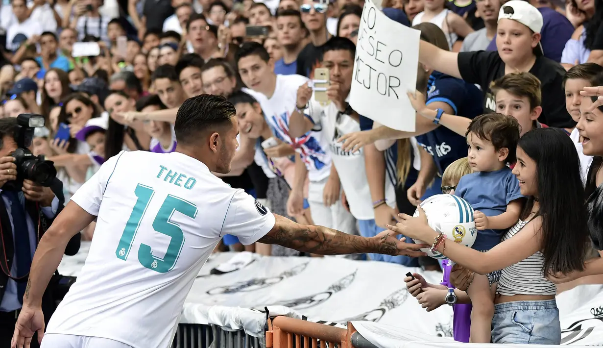 Pemain baru Real Madrid, Theo Hernandez, menyapa suporter saat baru diperkenalkan di Stadion Santiago Bernabeu, Madrid, Senin (10/7/2017). (AFP/Javier Soriano)