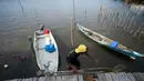 Seorang pria menaiki perahu di desa Sebulang di Pulau Rempang. Foto yang diambil pada tanggal 18 September 2023. (Bay Ismoyo/AFP)