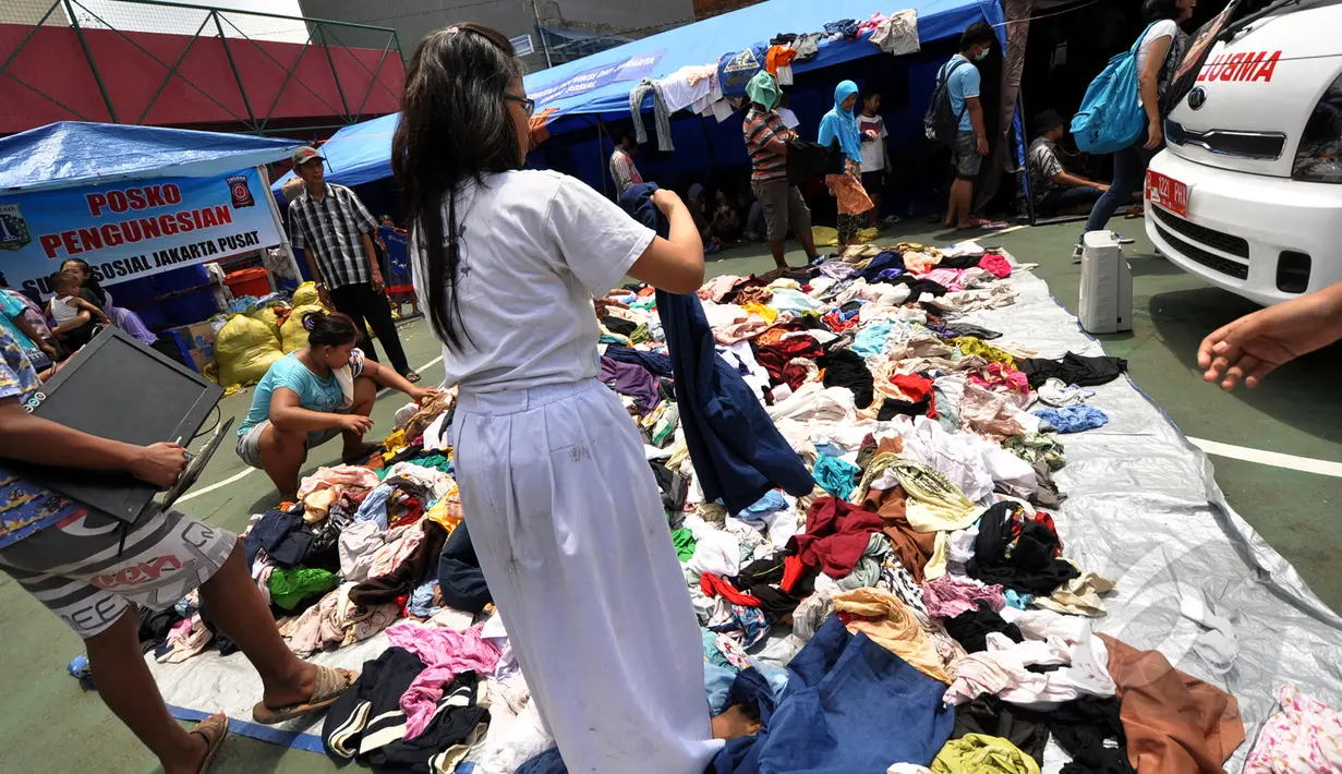 Sejumlah anak pengungsi kebakaran mencari pakaian layak pakai di posko pengungsian di Kebon Melati, Tanah Abang, Jakarta, Jumat (6/3/2015). Kebakaran hebat pada Kamis (5/3) petang menyebabkan setidaknya 1.600 warga mengungsi. ( Liputan6.com/Faizal Fanani)
