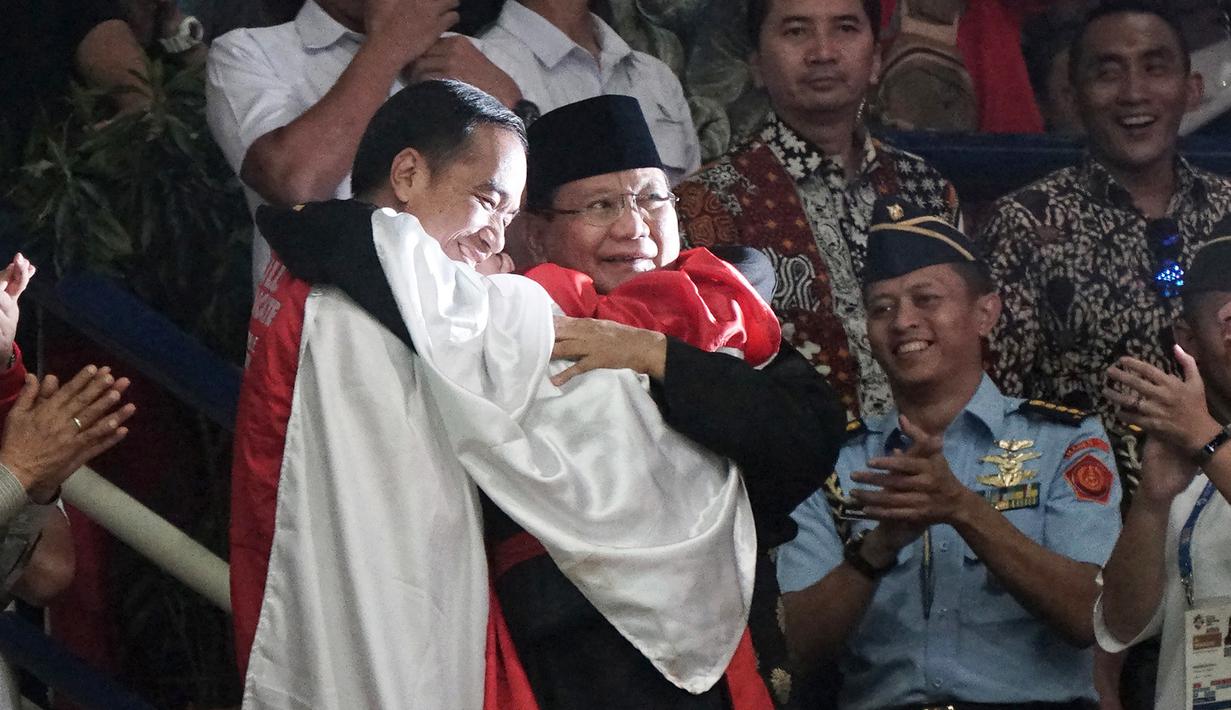 Presiden RI, Joko Widodo dan Ketua Umum IPSI, Prabowo Subianto, berpelukan dengan peraih medali emas pencak silat, Hanifan Yudani di Padepokan Pencak Silat TMII, Jakarta, Rabu (29/8). ANTARA FOTO/Kumparan/INASGOC/Aditia Noviansyah/pras/18