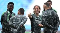 Pemain Real Madrid, Luka Modric (tengah) bercanda dengan rekannya saat melakukan latihan menjelang laga semifinal Liga Champions 2022/2023 melawan Manchester City di Etihad Stadium, Manchester, Selasa (16/05/2023) waktu setempat. (AFP/Oli Scarff)