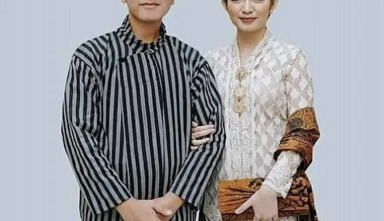 Selvi juga mengenakan kebaya putih lengkap dengan bros, dipadukan slendang, clucth, dan kain motif batik warna cokelat.