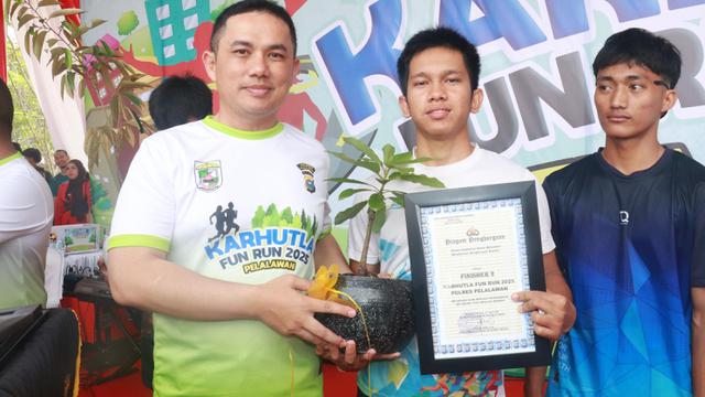 Penyerahan bibit pohon durian kepada peserta Karhutla Fun Run 2025.