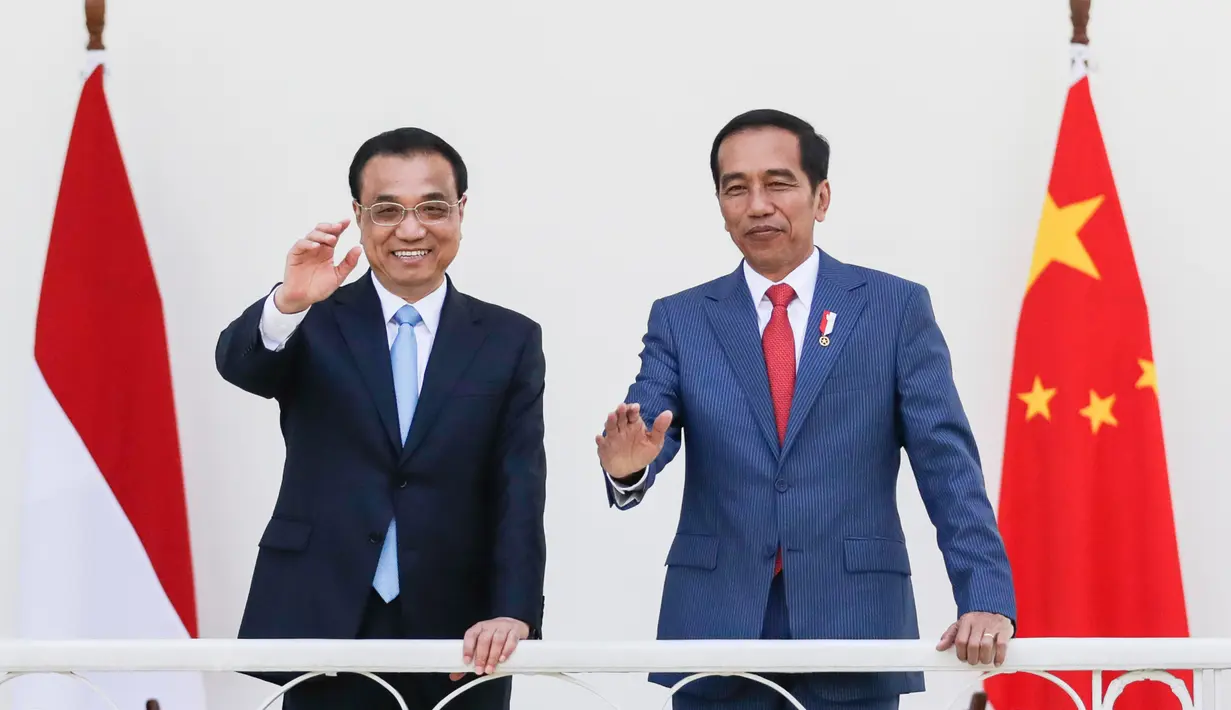 Presiden Joko Widodo (Jokowi) bersama PM China Li Keqiang melambaikan tangan kepada jurnalis di beranda Istana Bogor, Senin (7/5). Kerja sama perdagangan dan investasi merupakan isu utama yang akan dibahas Li dan Jokowi. (Mast Irham/Pool via AP)