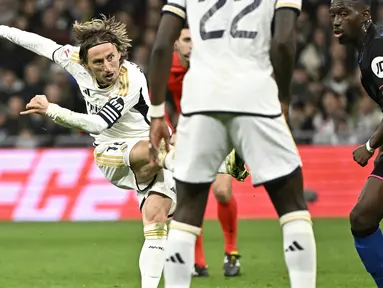 Pemain Real Madrid, Luka Modric mencetak gol ke gawang Sevilla dari luar kotak penalti pada laga lanjutan Liga Spanyol 2023/2024 di Stadion Santiago Bernabeu, Madrid, Spanyol, Senin (26/02/2024) dini hari WIB. Los Blancos menang dengan skor 1-0. (AFP/Javier Soriano)