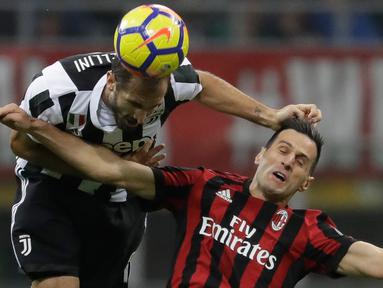 Pemain Juventus, Giorgio Chiellini menyundul bola dari pemain AC MIlan, Nikola Kalinic pada lanjutan Liga Italia di Stadion San Siro, Milan, Sabtu (28/10). Gonzalo Higuain memborong gol kemenangan saat Juventus mempermalukan Milan 2-0. (AP/Luca Bruno)