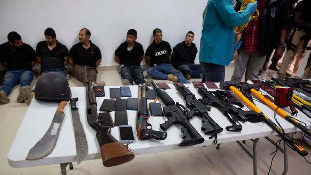 Para tersangka pembunuhan Presiden Haiti Jovenel Moise, beserta senjata dan peralatan yang diduga mereka gunakan, ditunjukkan kepada media di Port-au-Prince pada 8 Juli 2021 (AP Photo/Joseph Odelyn)