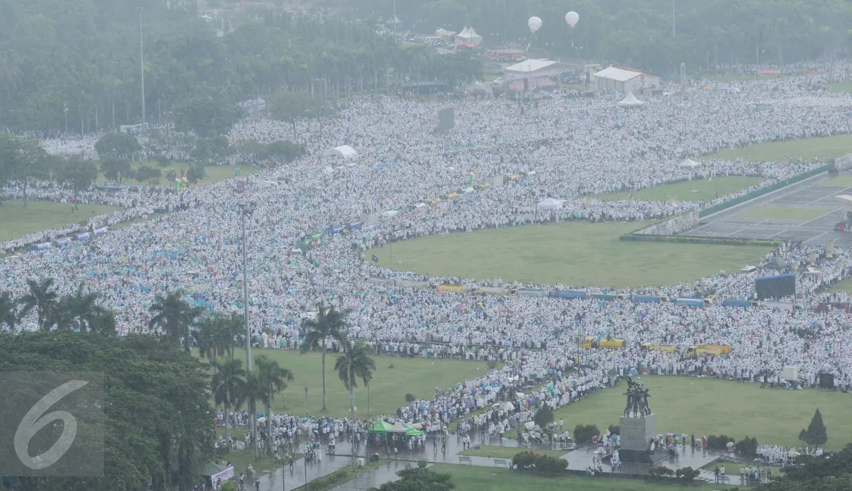 Ribuan massa aksi damai 2 Desember yang akan melaksanakan ibadah salat Jumat memadati kawasan Monas, Jakarta, Jumat (2/12). Para peserta doa bersama tetap melaksanakan ibadah Salat Jumat meskipun kondisi cuaca hujan. (Liputan6.com/Gempur M Surya)