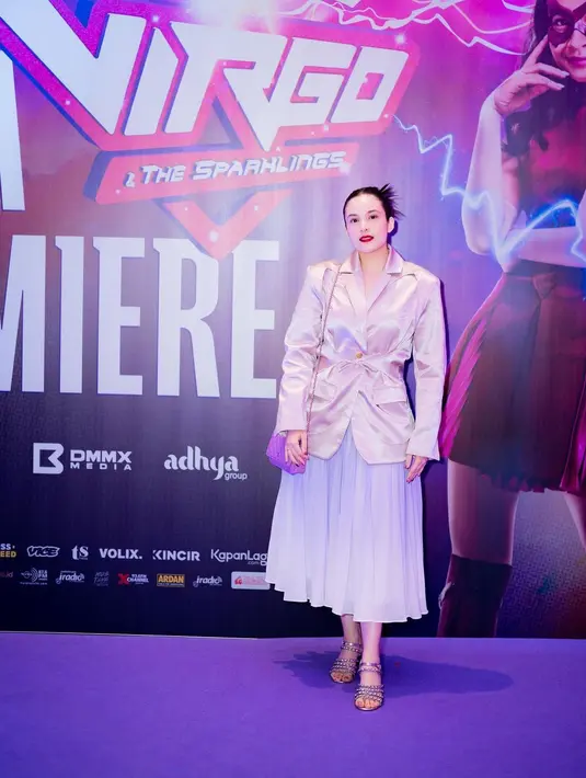 Ia mengenakan blazer satin soft pink dengan pleated midi skirt. [@chelseislan]