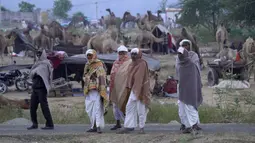 Penggembala unta berdiri berbalut syal saat pameran ternak tahunan di Pushkar, India, 11 November 2021. Pushkar adalah tempat ziarah Hindu populer yang juga sering dikunjungi oleh turis asing pada pameran ternak tahunannya. (AP Photo/Deepak Sharma)