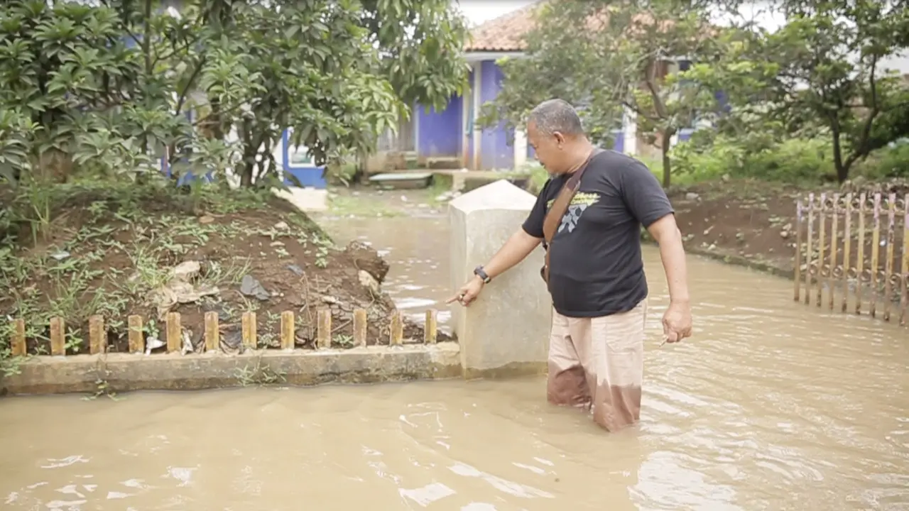 Pagar Terlihat Tenggelam Akibat Penurunan Tanah