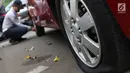 Petugas menderek dan menggembosi ban mobil yang parkir sembarangan di kawasan Tebet, Jakarta, Kamis (28/3). Meskipun berulang kali ditertibakan, namun masih banyak pengendara yang nekat parkir sembarangan sehingga mengganggu arus lalu lintas. (Liputan6.com/Immanuel Antonius)