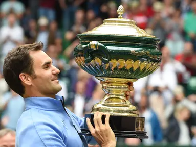 Roger Federer mengangkat trofi juara ATP Tour Jerman usai mengalahkan petenis Jerman, Alexander Zverev 6-1, 6-3 di Gerry Weber Open tennis tournament, Halle, Jerman, (25/6/2017), (AFP/Carmen Jaspersen)