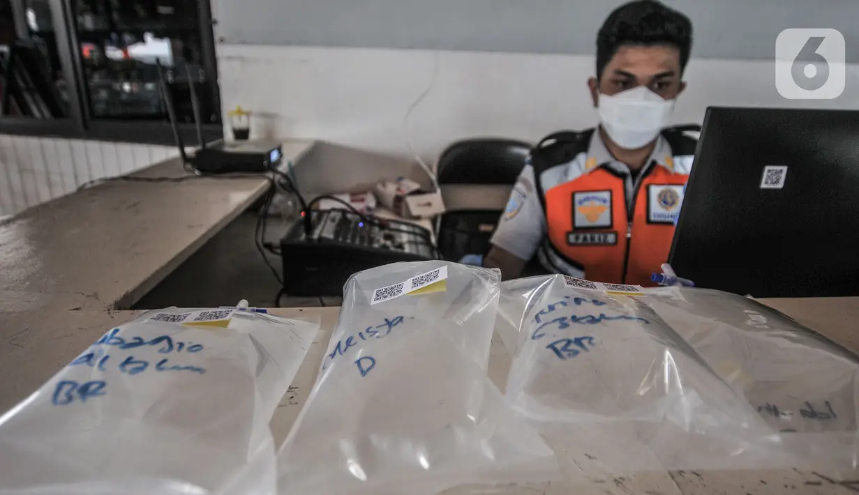 Petugas menguji sampel tes Genose milik pemudik yang baru tiba di Terminal Kampung Rambutan, Jakarta, Minggu (23/5/2021). Pengelola Terminal Kampung Rambutan memberlakukan tes Genose sebagai syarat wajib bagi para pemudik yang baru tiba guna memutus penyebaran Covid-19. (merdeka.com/Iqbal S Nugroho)