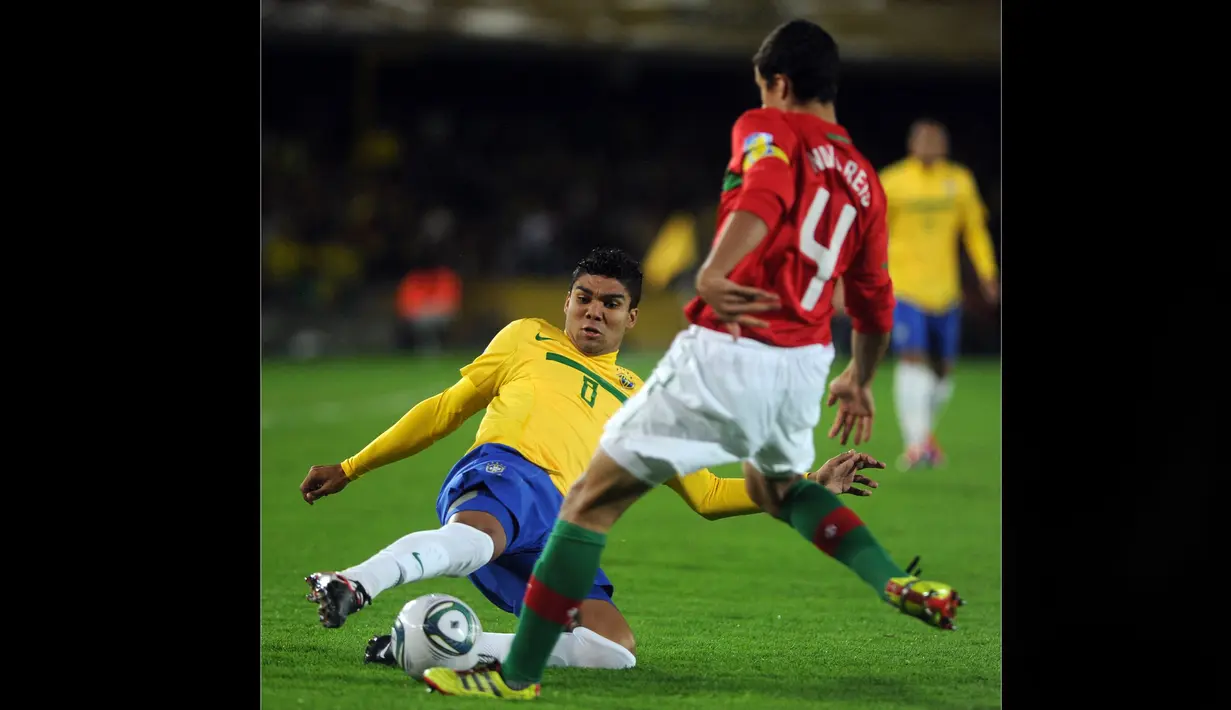 Pemain Timnas Brasil U-20, Casemiro (kiri) berusaha merebut bola dari pemain Portugal U-20, Nuno Reis pada pertandingan final Piala Dunia U-20 2011 yang berlangsung di El Campin, Bogota, Kolombia, Sabtu (20/8/2011). (AFP/Eitan Abramovic)