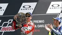 Ekspresi Jorge Lorenzo (kiri) dan Valentino Rossi pada podium MotoGP 2018, di Sirkuit Mugello, Minggu (3/6/2018). (AP Photo/Antonio Calanni)