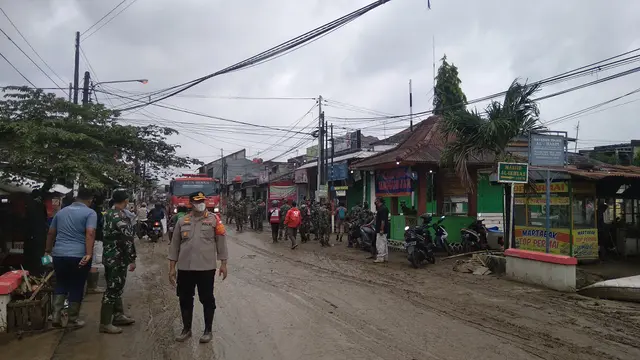 Petugas gabungan membersihkan lumpur akibat banjir di Perumahan Pondok Gede Permai, Jatiasih, Kota Bekasi