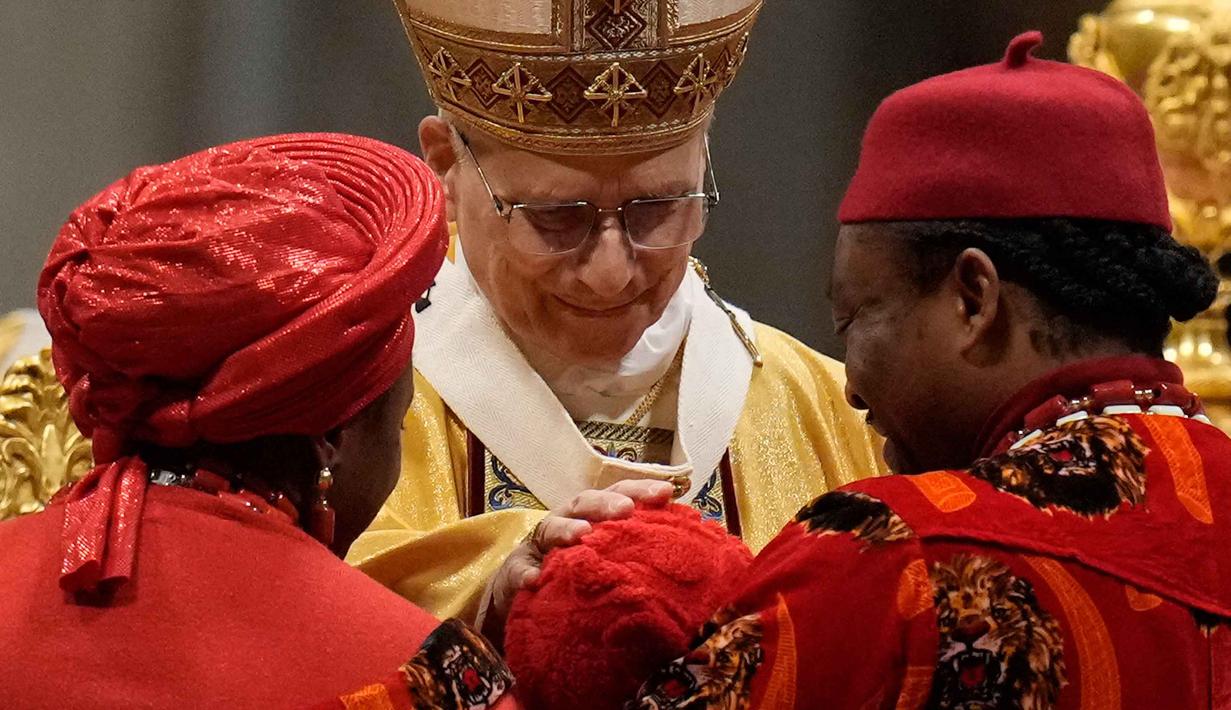 Paus Leo XIV juga menegaskan bahwa Natal harus menjadi pengingat untuk membela kaum papa dan terlupakan. Tampak dalam foto, Paus Leo XIV memberkati seorang anak selama Misa Malam Natal di Basilika Santo Petrus, Vatikan, Rabu 24 Desember 2025. (AP Photo/Gregorio Borgia)