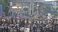 Polisi membuat barikade saat terjadi bentrok dengan massa aksi di kawasan Tanah Abang, Jakarta, Rabu (22/5/2019). Beberapa kelompok massa menggunakan benda-benda keras hingga mercon untuk menahan laju petugas keamanan. (Liputan6.com/Herman Zakharia)