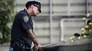 Ekspresi petugas New York City Police Department (NYPD) selama peringatan 16 tahun korban serangan 11 September di Museum dan Memorial Nasional 9/11, New York, Amerika Serikat, Senin (11/9). (Drew Angerer/Getty Images/AFP)
