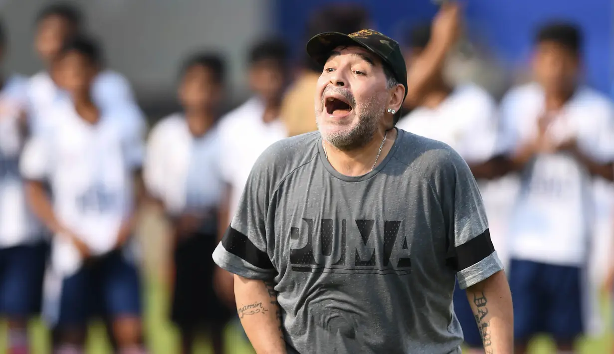 Legenda sepak bola, Diego Maradona, memberikan pelatihan kepada anak-anak di Barasat, Selasa (12/12/2017). Kunjungan ini dilakukan pria asal Argentina itu dalam rangkaian liburan. (AFP/Dibyangshu Sarkar)