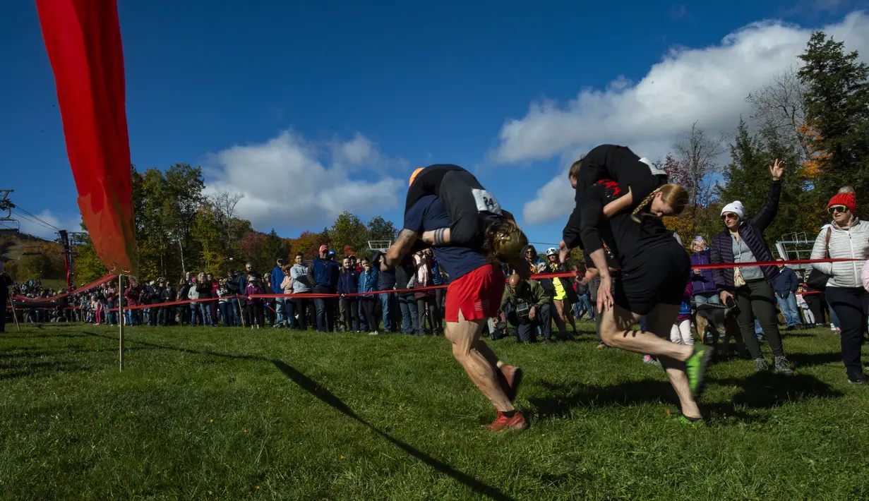 Tim berangkat untuk memperebutkan juara ketiga dan keempat pada North American Wife Carrying Championship di Sunday River Resort di Newry, Maine, pada 8 Oktober 2022. Lintasan yang harus dilalui pun cukup sulit. Panjang lintasan kurang lebih 253,5 meter. (Joseph Prezioso / AFP)