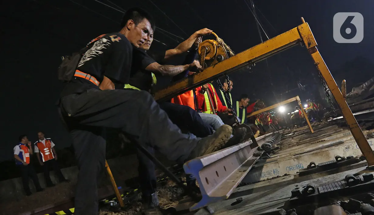Sejumlah petugas merevitalisasi wesel rel di Stasiun KA Gambir, Jakarta, Kamis (14/2/2020) malam. PT KCI dan PT KAI Daop 1 Jakarta mengganti wesel rel di Stasiun Gambir dan Stasiun Jakarta Kota secara paralel yang akan berlangsung pada 13-23 Februari 2020. (Liputan6.com/Herman Zakharia)